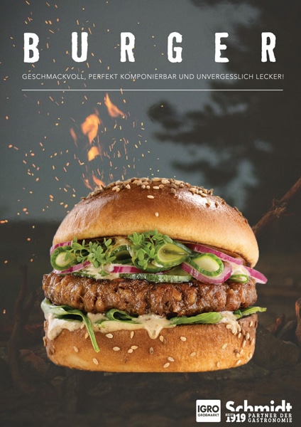 Deckblatt eines Flyers mit dem Titel „BURGER“. Gezeigt wird ein saftiger Burger in einem Sesambrötchen, belegt mit einem Fleisch-Patty, Saucen, grünem Salat, Gurkenscheiben und roten Zwiebelringen. Im Hintergrund sind Funken und Flammen vor einem dunklen Waldmotiv zu sehen. Am unteren Rand befinden sich die Logos von IGRO Großmarkt und Fisch Schmidt.