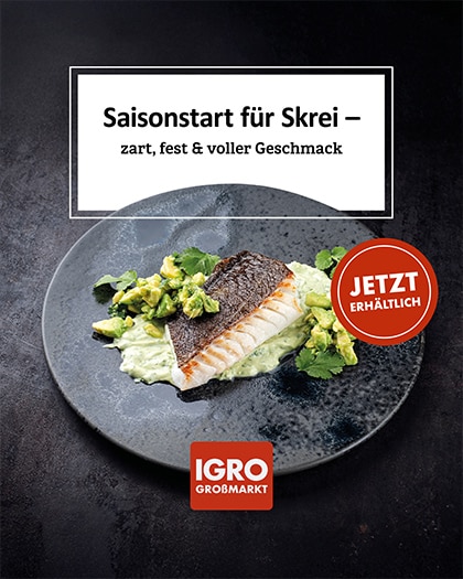 Ein professionelles Food-Foto von einem gebratenen Skrei-Fischfilet, serviert auf einem dunklen Teller mit frischen Avocado-Stücken und einer grünen Sauce. Ein weißer Banner oben kündigt den „Saisonstart für Skrei“ an. Das Bild enthält das IGRO Großmarkt Logo und ein Siegel mit dem Text „JETZT ERHÄLTLICH“.