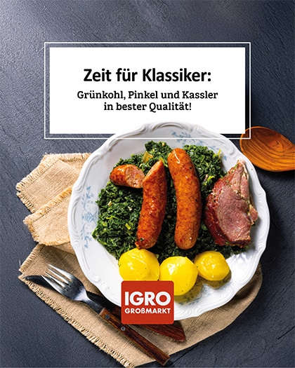 Appetitliche Nahaufnahme eines klassischen Wintergerichts zur Grünkohlzeit: Ein weißer Porzellanteller mit Grünkohl, zwei Pinkelwürsten, einem Stück Kassler und Salzkartoffeln. Der Teller steht auf einer hellen Leinenserviette auf einem dunklen Steintisch, daneben liegen Besteck und ein Holzlöffel. Ein weißes Textfeld darüber zeigt den Text: „Zeit für Klassiker: Grünkohl, Pinkel und Kassler in bester Qualität!“. Unten ist das rote IGRO Großmarkt Logo platziert. Alles bereit für die Grünkohlzeit.