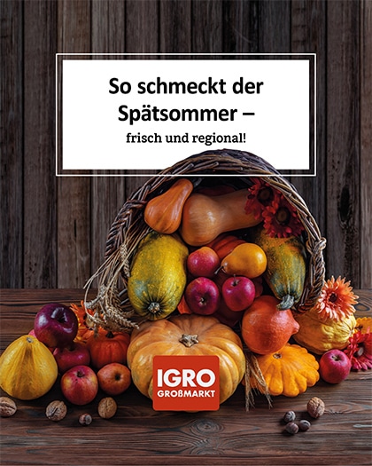 Nahaufnahme eines rustikalen Füllhorns auf einem dunklen Holztisch, das mit herbstlichem Obst und Gemüse wie verschiedenen Kürbissorten (Hokkaido, Butternuss), Äpfeln und Walnüssen gefüllt ist. Ein weißes Textfeld darüber trägt die Aufschrift: „So schmeckt der Spätsommer – frisch und regional!“. Unten ist das rote IGRO Großmarkt Logo platziert. Ein stimmungsvolles Bild für frischen, regionalen Genuss.