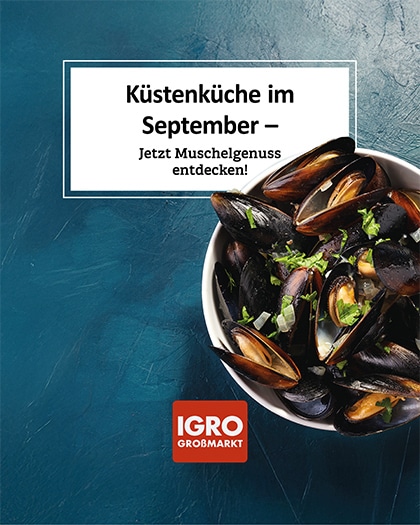 Appetitliche Nahaufnahme von frischen, gekochten Miesmuscheln in einer weißen Schale, serviert mit Kräutern und Zwiebeln. Der Teller steht auf einer dunkelblauen, rustikalen Steinoberfläche. Ein weißes Textfeld darüber zeigt den Text: „Küstenküche im September – Jetzt Muschelgenuss entdecken!“. Unten ist das rote IGRO Großmarkt Logo platziert. Ein Highlight zur maritimen Muschelzeit.